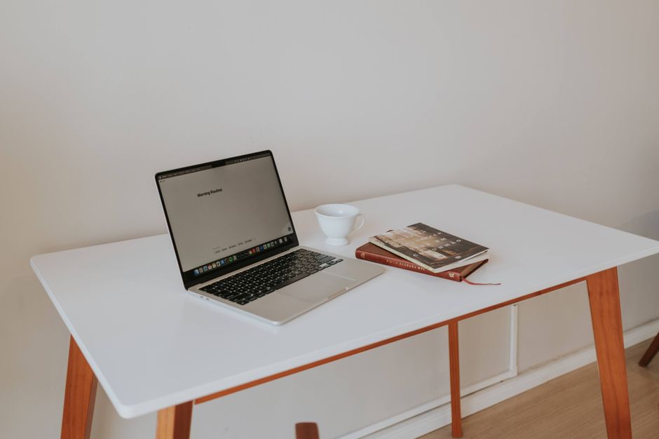 Espacio de trabajo minimalista con laptop, café y libros
